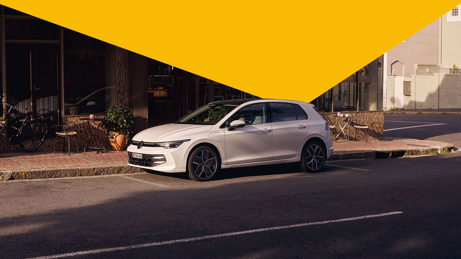 The Gulf of Volkswagen in front of a building (with yellow design element triangle above)