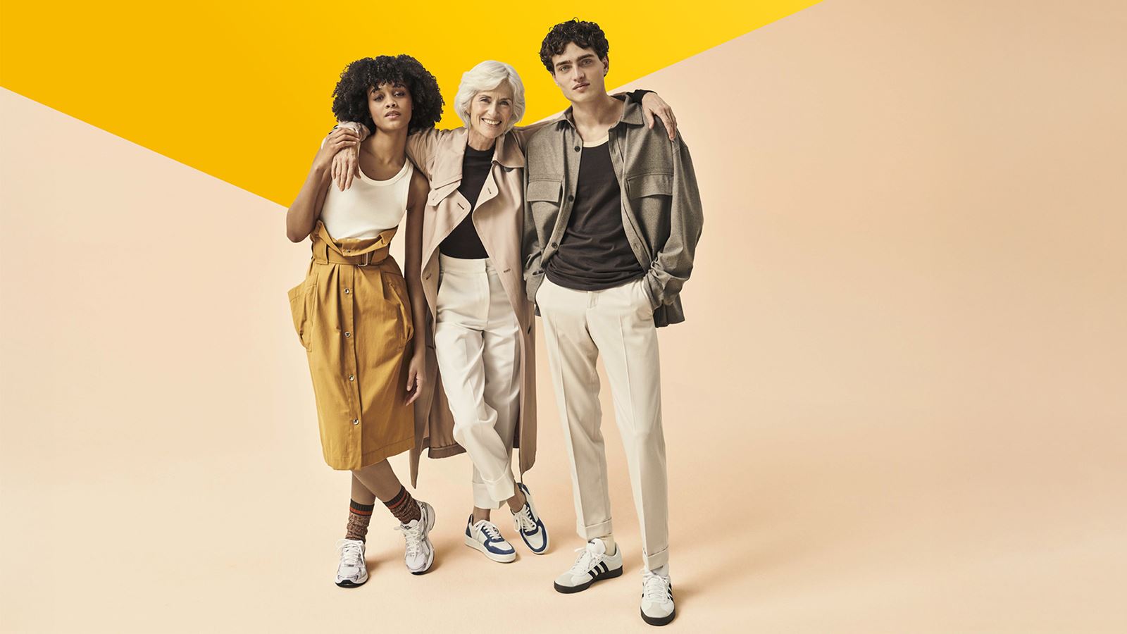 Tre persone alla moda su uno sfondo di rosa pesca (con un elemento di design giallo sporgente)