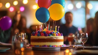 Birthday cake with candles and balloons