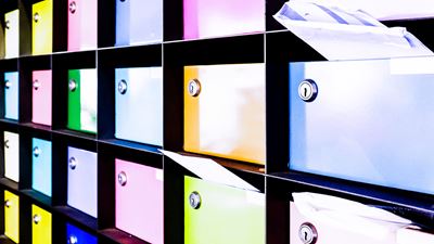 Farbige Briefkasten mit Postkarten im Einwurf