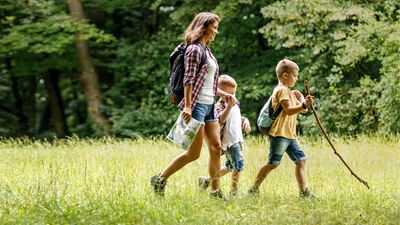 Une femme avec deux enfants se promène dans la nature