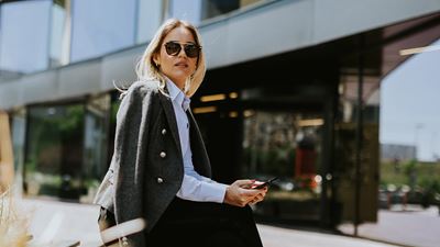 Frau sitzt in der Sonne mit einer Sonnenbrille