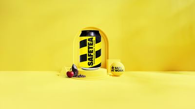 Der SAFETEA Eistee von SAFE AT WORK mit Kirsche und Schokolade vor einem gelben Hintergrund.